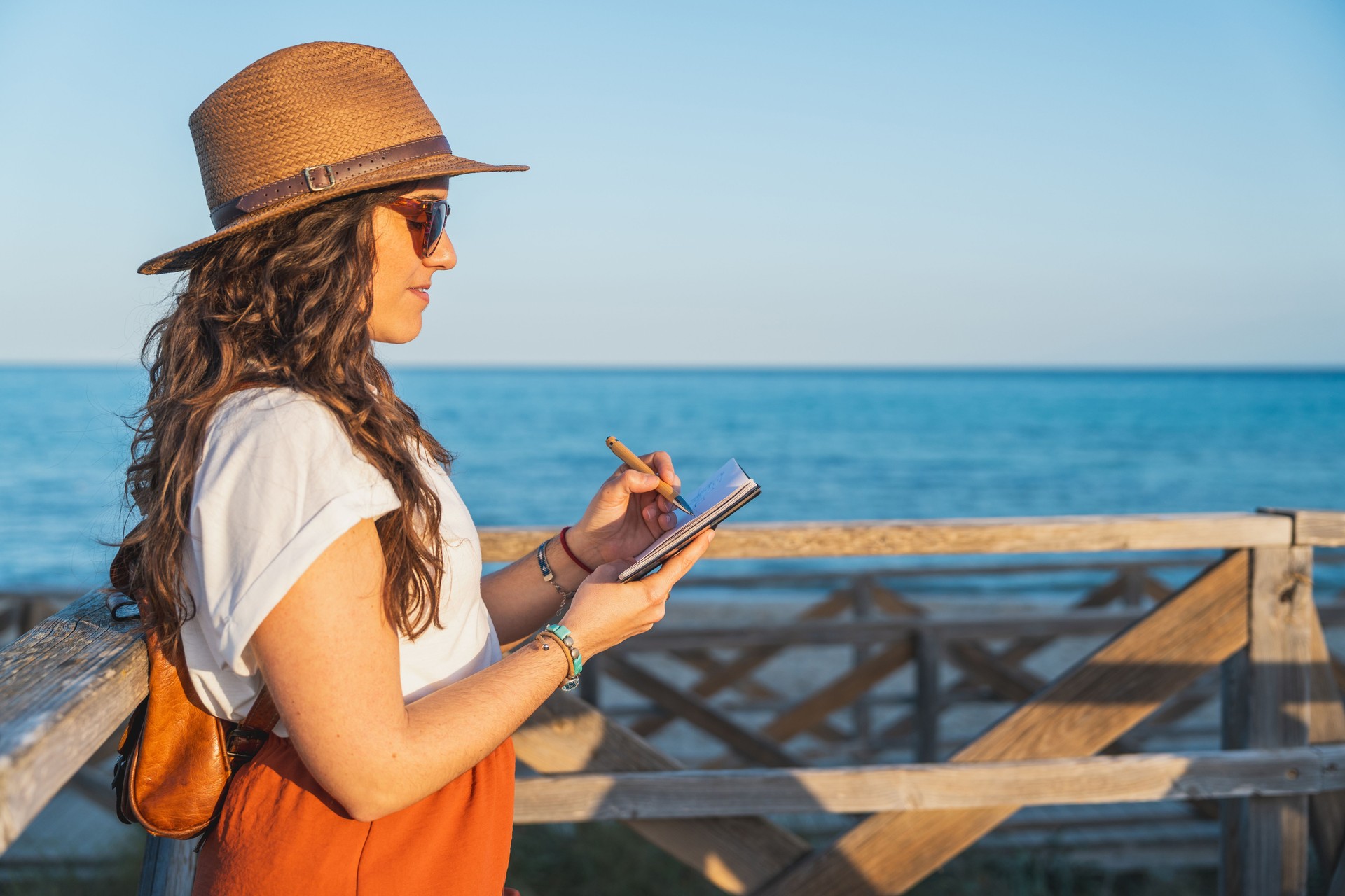Woman Writing in Notebook with Ocean View in Mallorca
